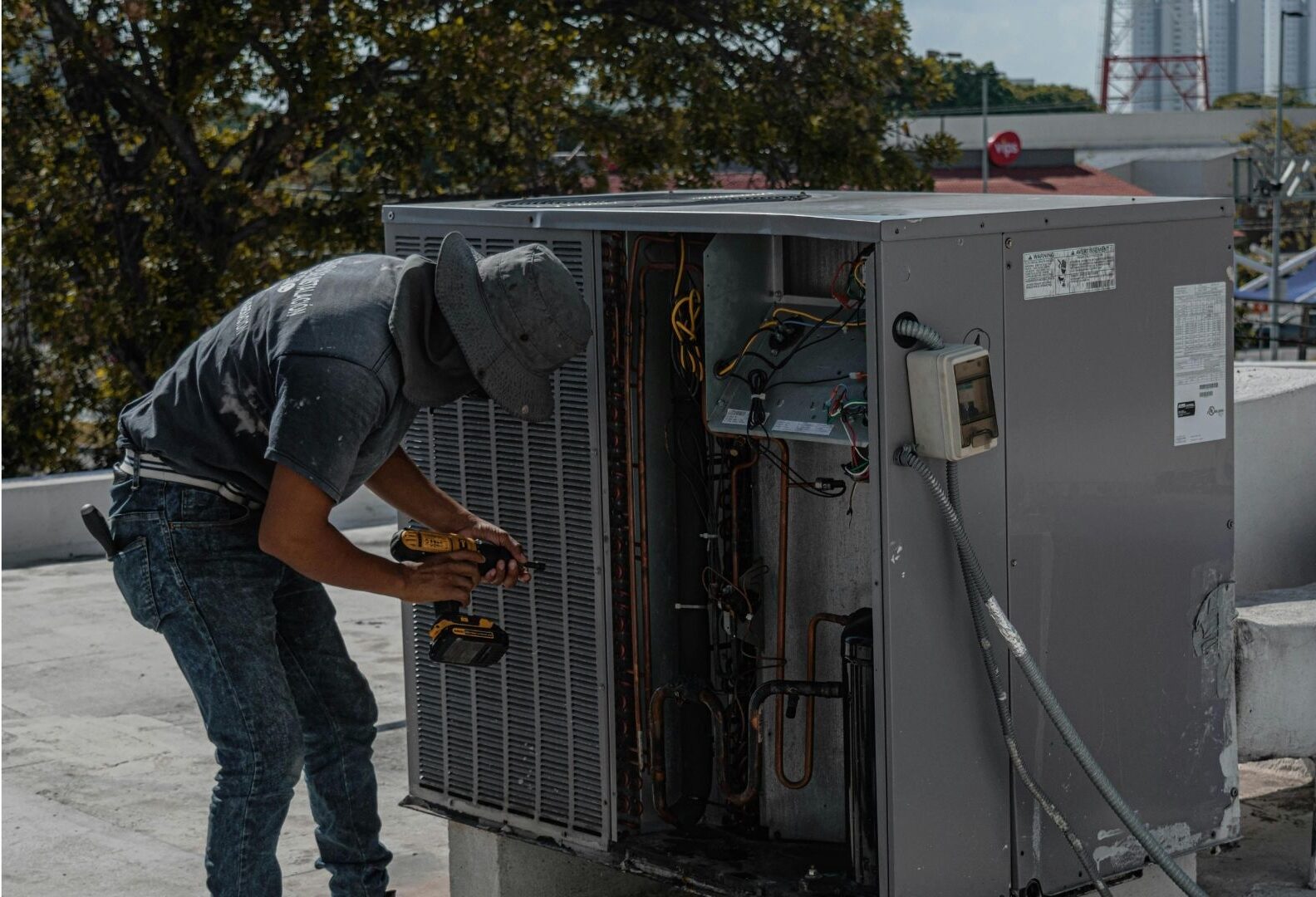 Cool N Heat technician performing a seasonal AC tune-up and safety inspection in Madera, CA.
