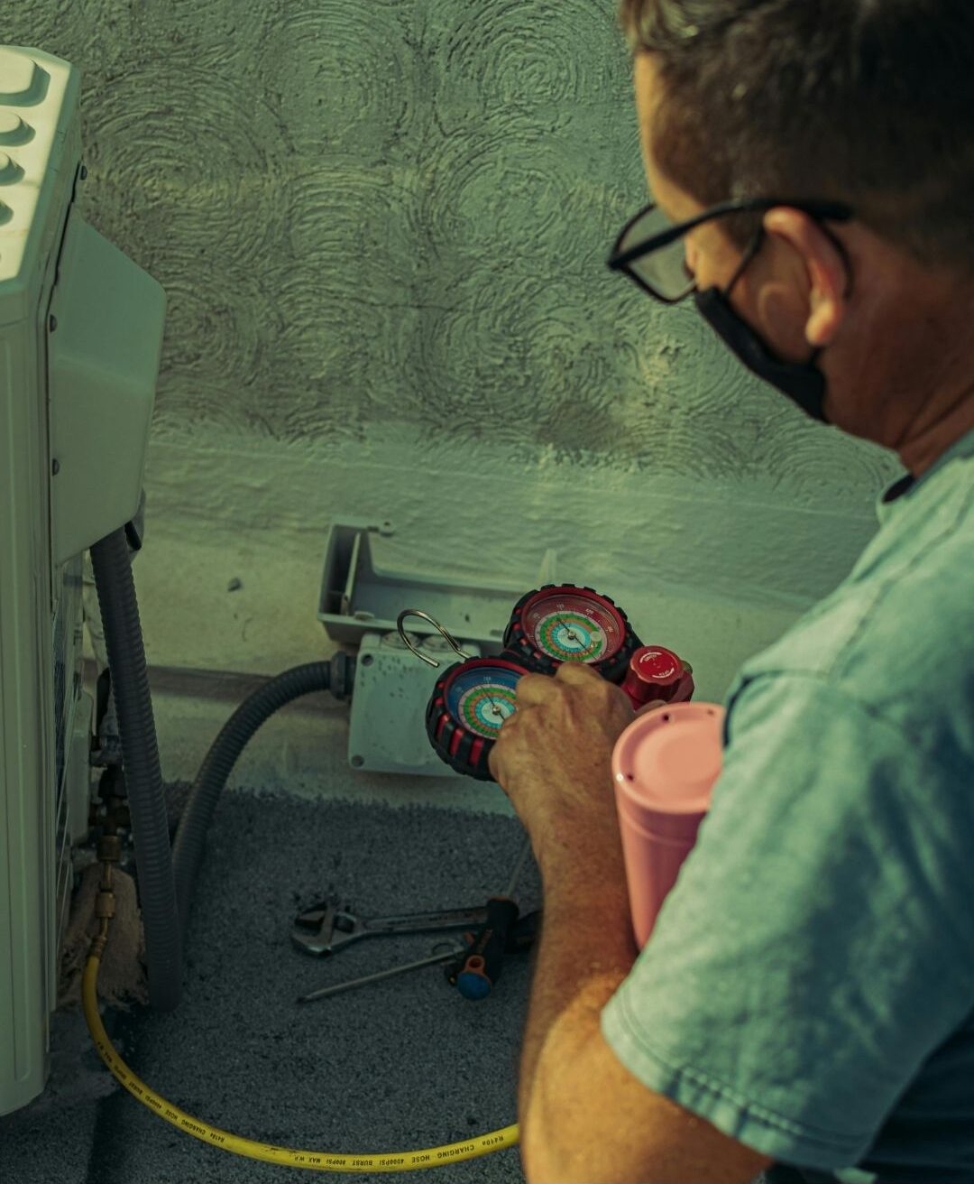 HVAC technician checking refrigerant levels and recharging an AC unit that is blowing warm air in Madera.