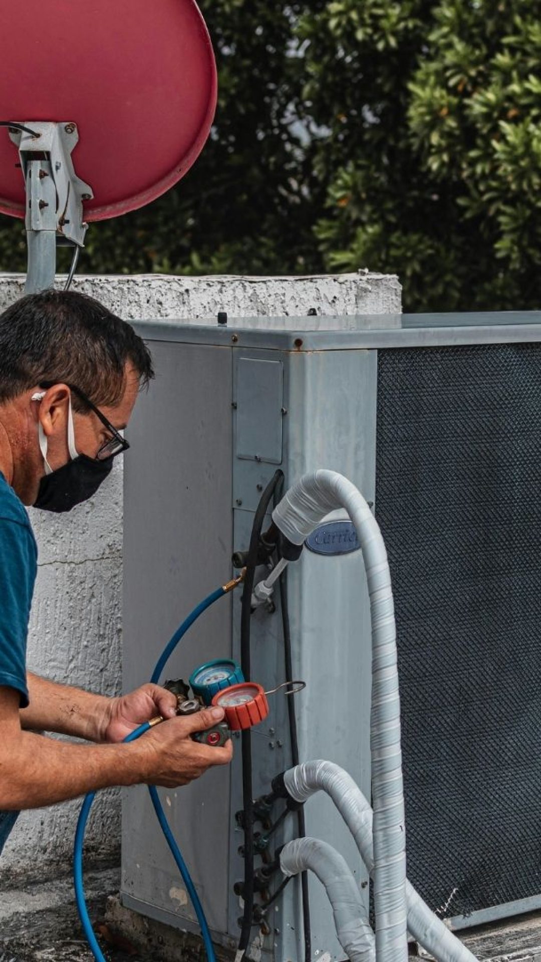 Cool N Heat technician performing preventive maintenance and repair on a Carrier air conditioning unit.